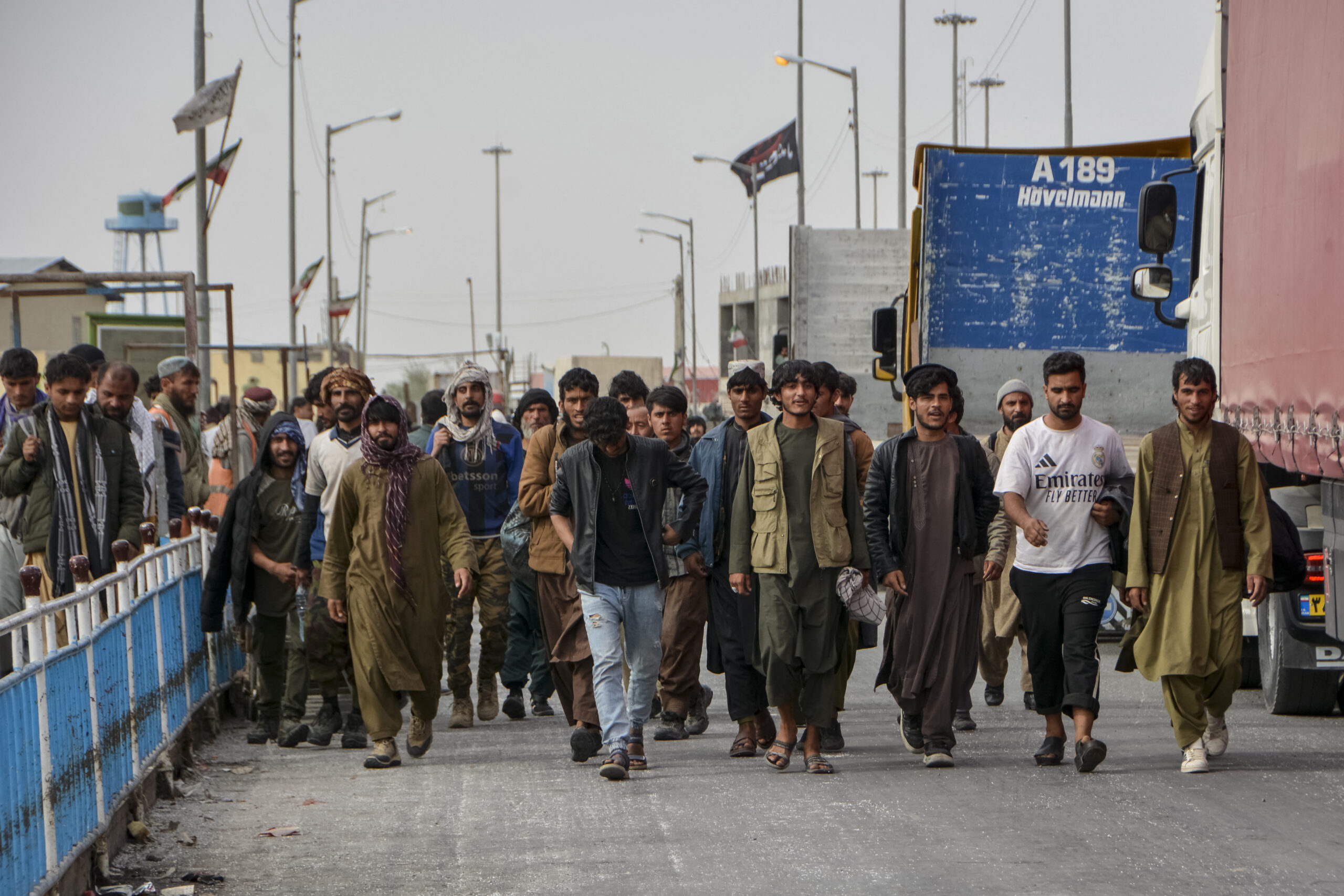 Afghan nationals walk upon their arrival from Iran at the Pul-e Abresham, or the Silk Bridge, at the Zero Point crossing between Afghanistan and Iran, in Zaranj, Nimruz province on March 5, 2026. Since US and Israeli strikes on February 28 triggered a regional war, Afghans crossing the border said they had left a frightening situation behind them. (Photo by AFP via Getty Images)