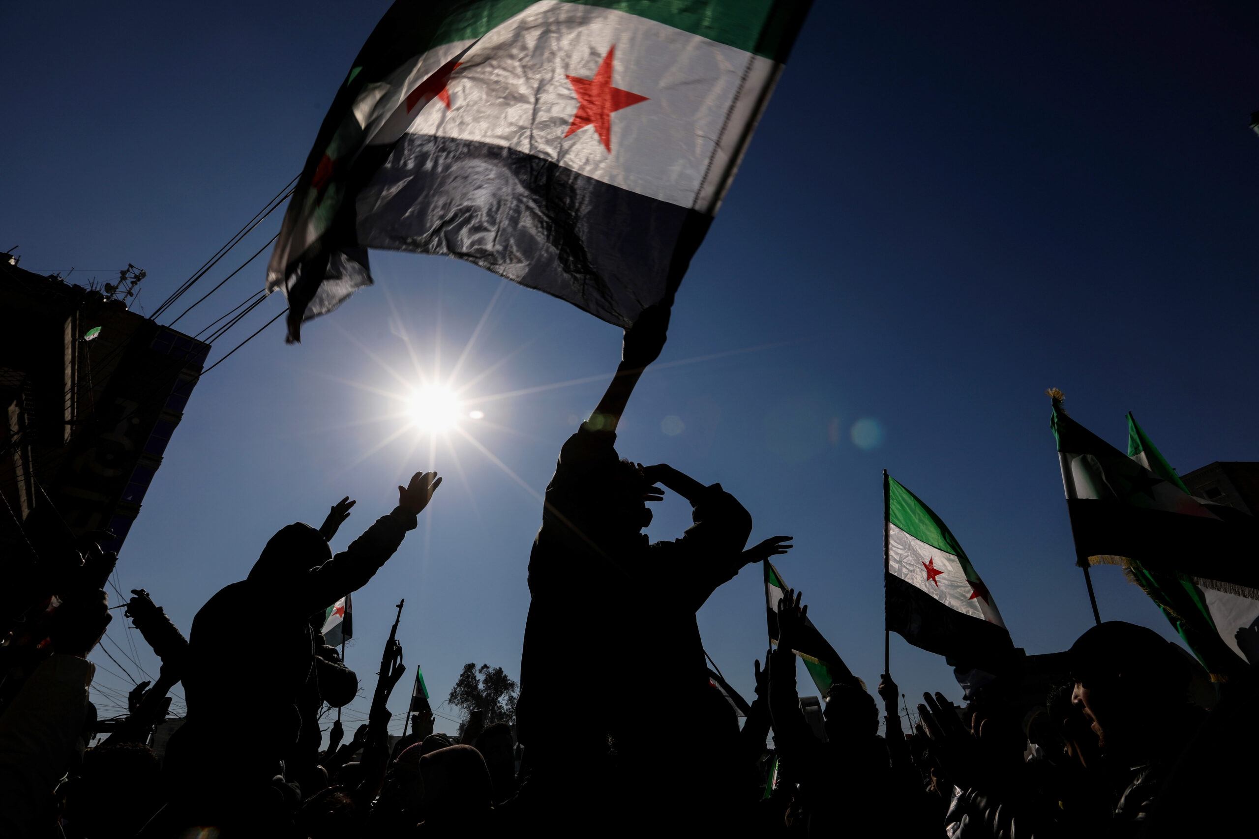 RAQQA, SYRIA - JANUARY 20: Syrian citizens celebrate and raise Syrian flags on January 20, 2026 in Raqqa, Syria. Syrian government forces recently took the area from the Kurdish-led Syrian Democratic Forces (SDF), who had been clashing with government forces in recent weeks. The Kurdish-led force, a long-time ally of the United States in the fight against ISIS, had controlled large swaths of northwest Syria during the years of the country's civil war. Both sides insist that negotiations are continuing over an agreement that would pave the way for the SDF to be integrated into Syria's military and state institutions. (Photo by Ahmad Hasaballah/Getty Images)