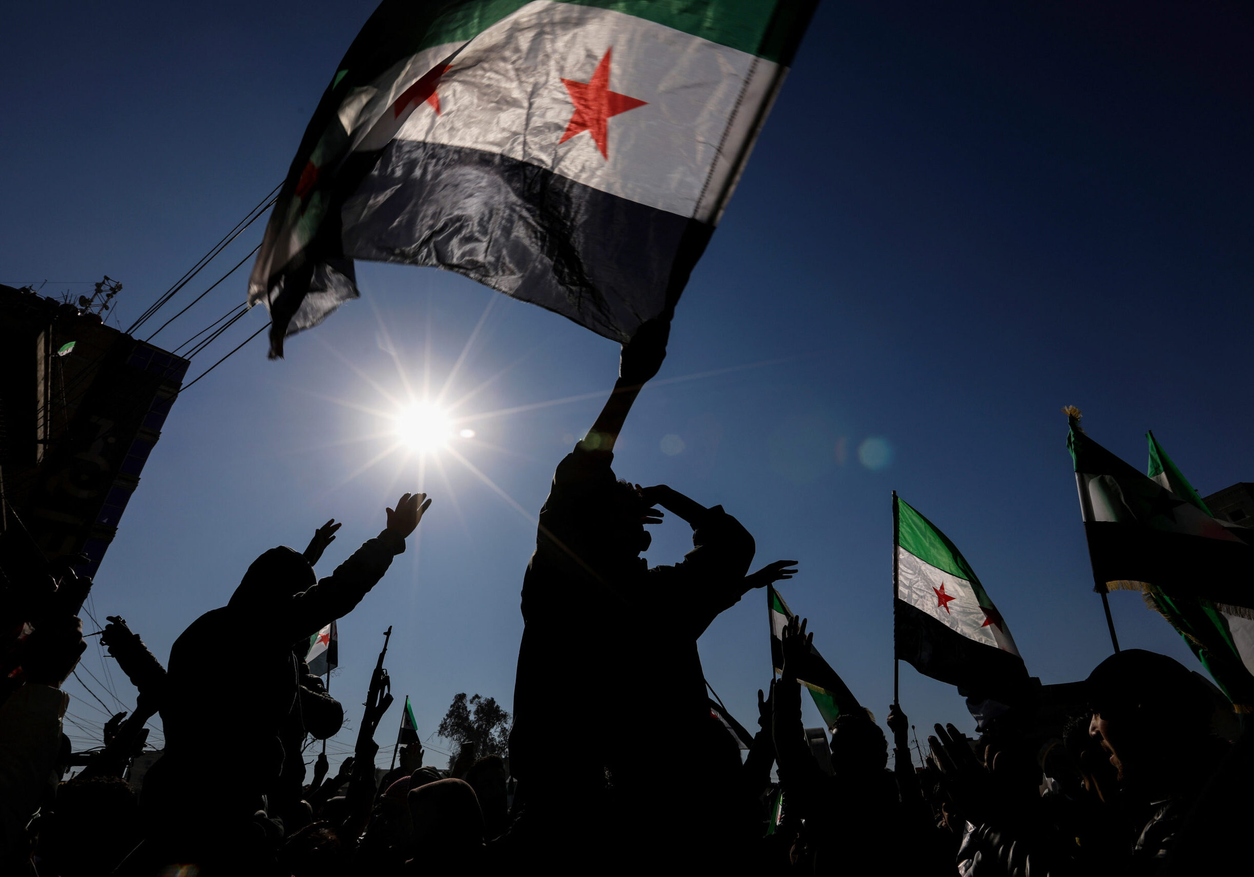 RAQQA, SYRIA - JANUARY 20: Syrian citizens celebrate and raise Syrian flags on January 20, 2026 in Raqqa, Syria. Syrian government forces recently took the area from the Kurdish-led Syrian Democratic Forces (SDF), who had been clashing with government forces in recent weeks. The Kurdish-led force, a long-time ally of the United States in the fight against ISIS, had controlled large swaths of northwest Syria during the years of the country's civil war. Both sides insist that negotiations are continuing over an agreement that would pave the way for the SDF to be integrated into Syria's military and state institutions. (Photo by Ahmad Hasaballah/Getty Images)